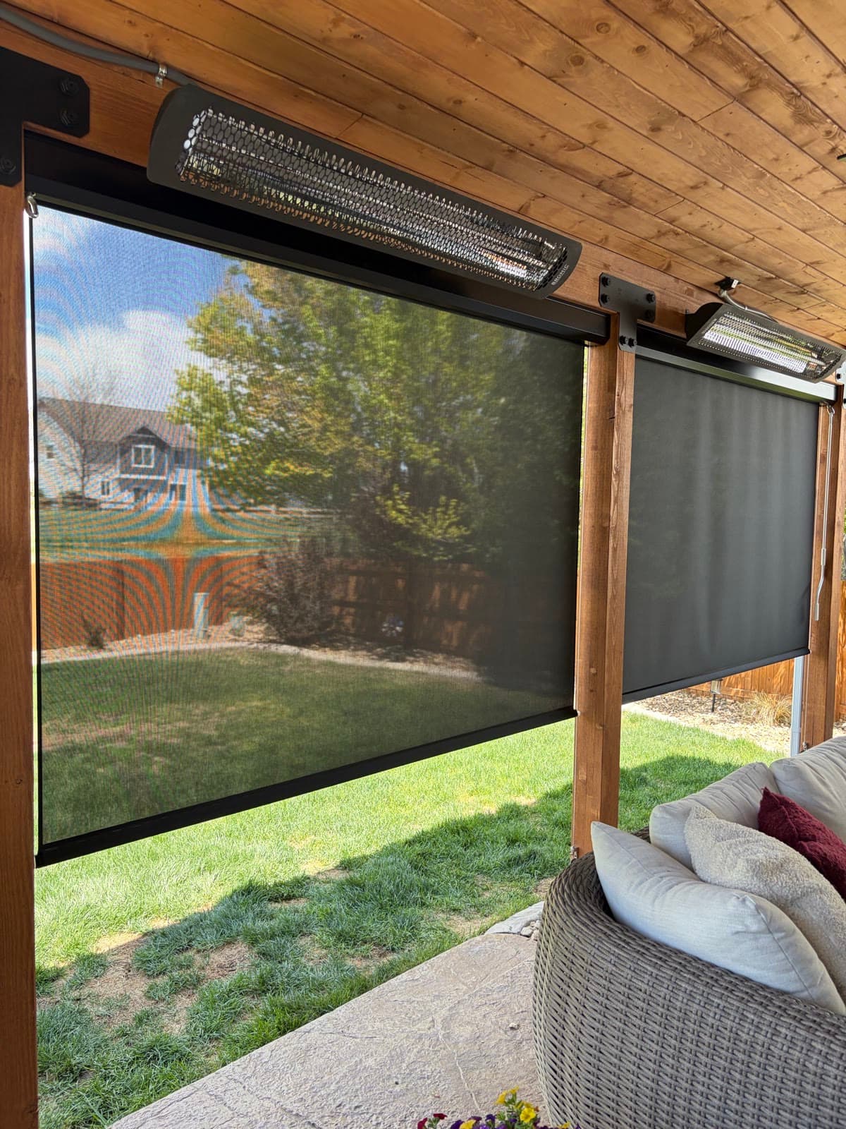 A retractable exterior screen framing the back yard from a covered patio