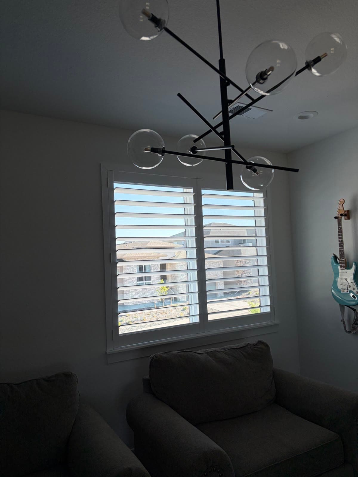 NewStyle® shutters in a sitting room with a guitar on the wall