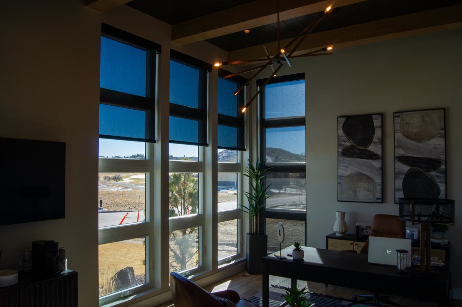 Screen fabric lowered across the office windows, the view still readable through it