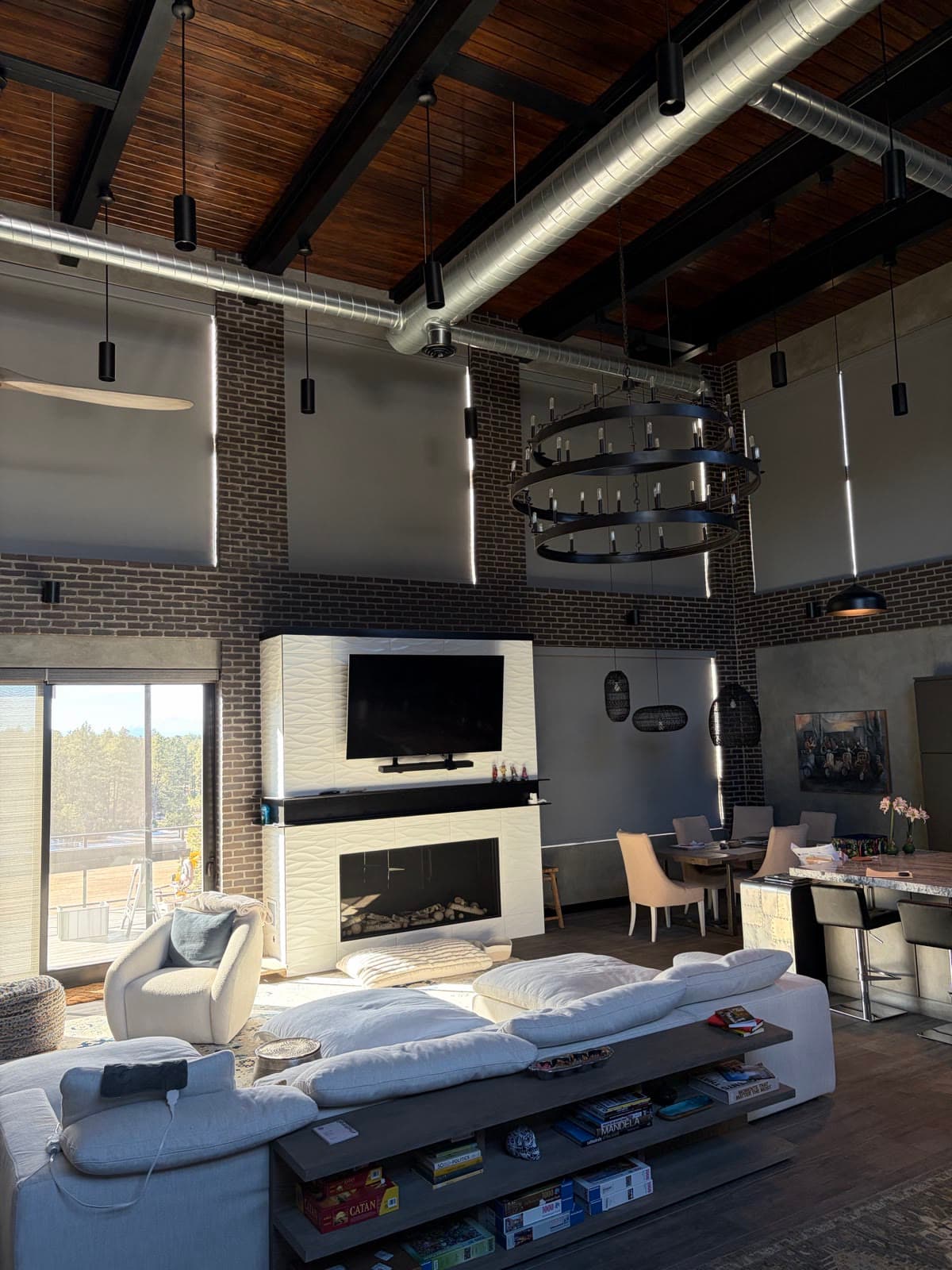 Roller shades on the tall brick walls of an industrial-style great room
