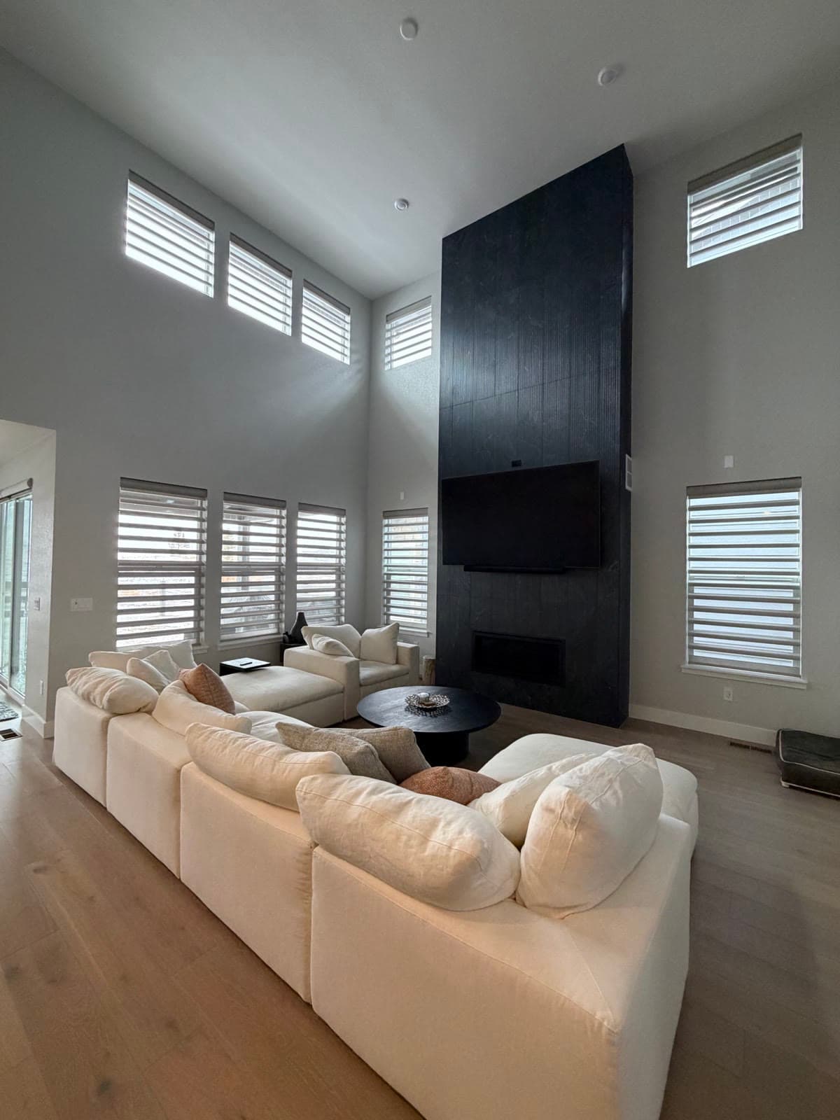 Sheer shadings on every window of a two-story great room, clerestories included