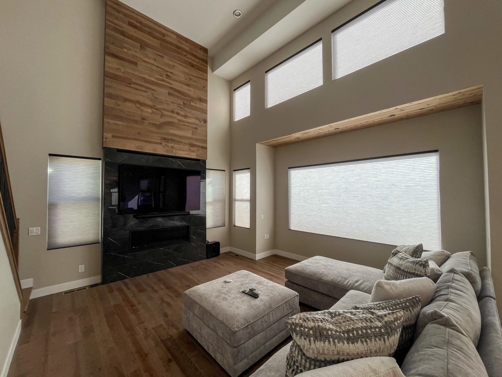 Cellular shades across a picture window and clerestory in a great room