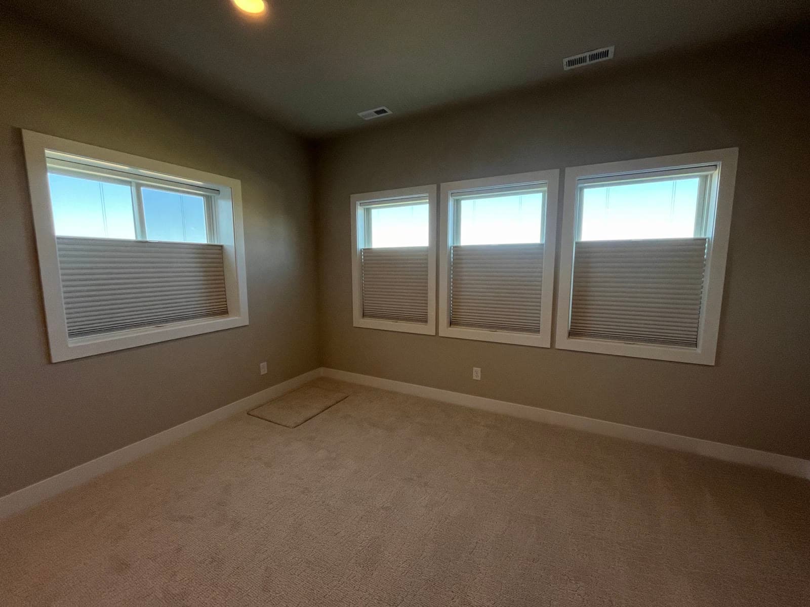 Top-down bottom-up cellular shades letting light in above a bedroom's privacy line