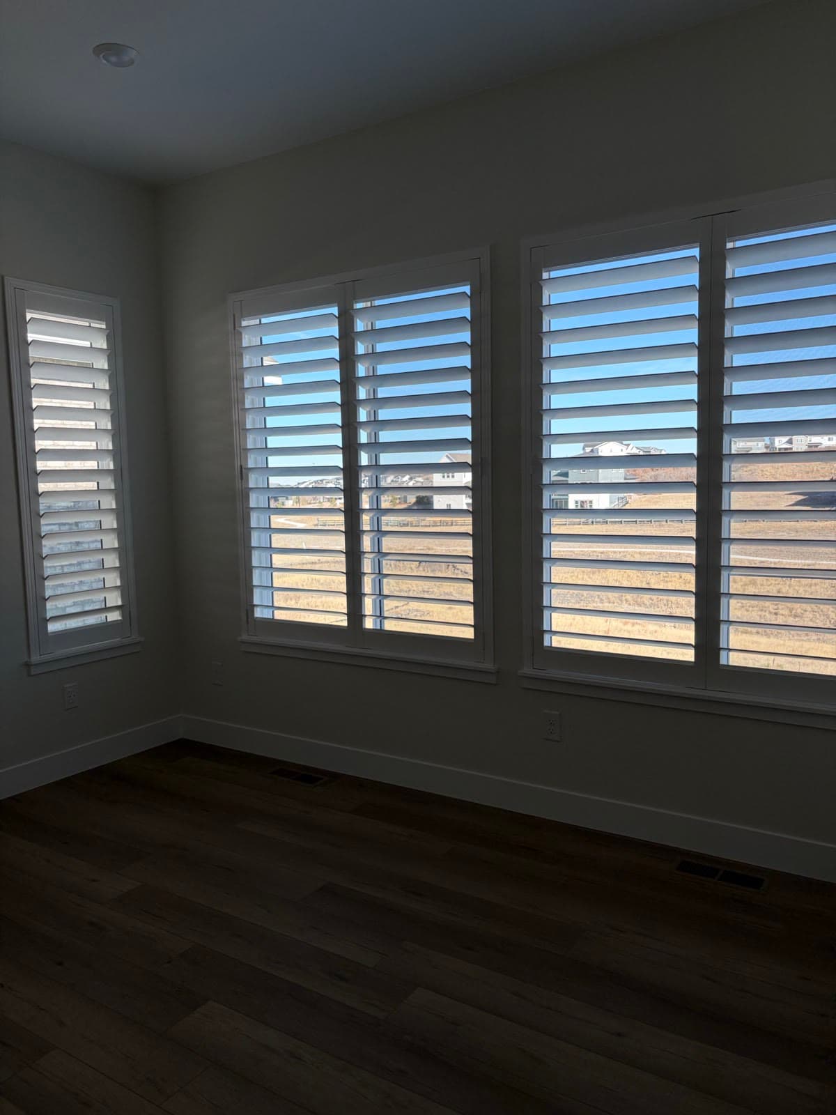 Plantation shutters on three windows with louvers tilted to the open space